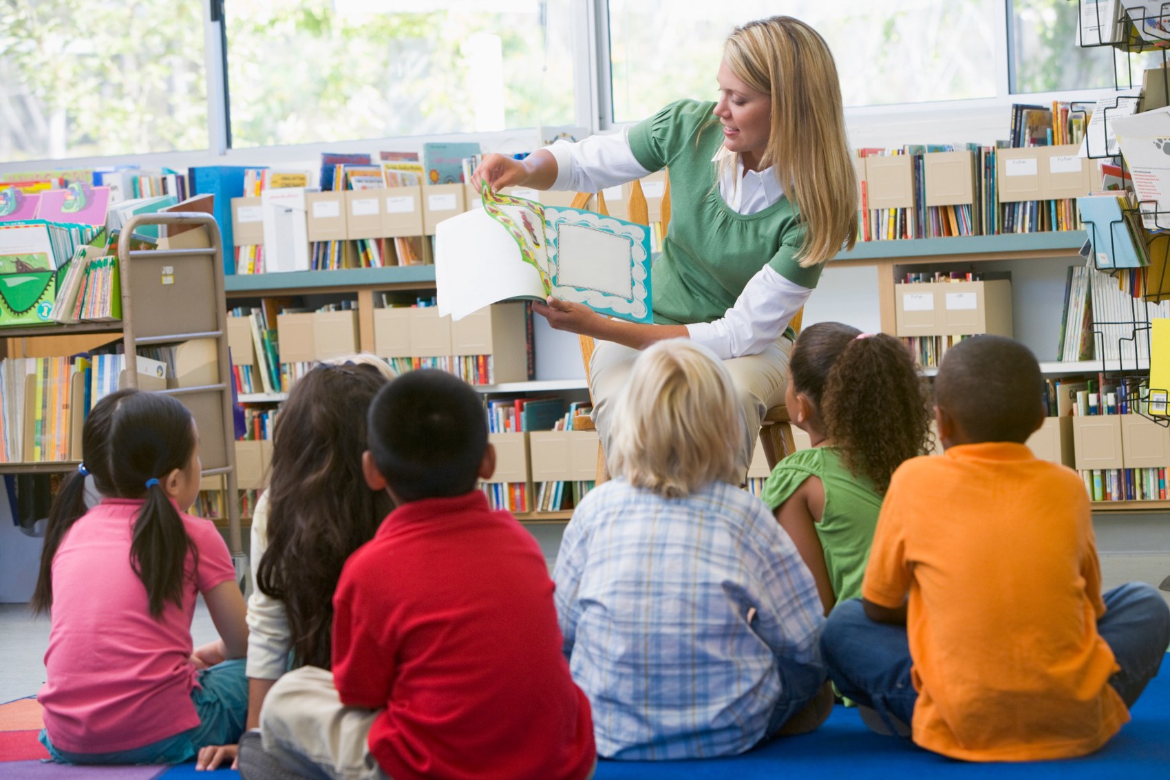 Teacher reading a picture book to a group of children