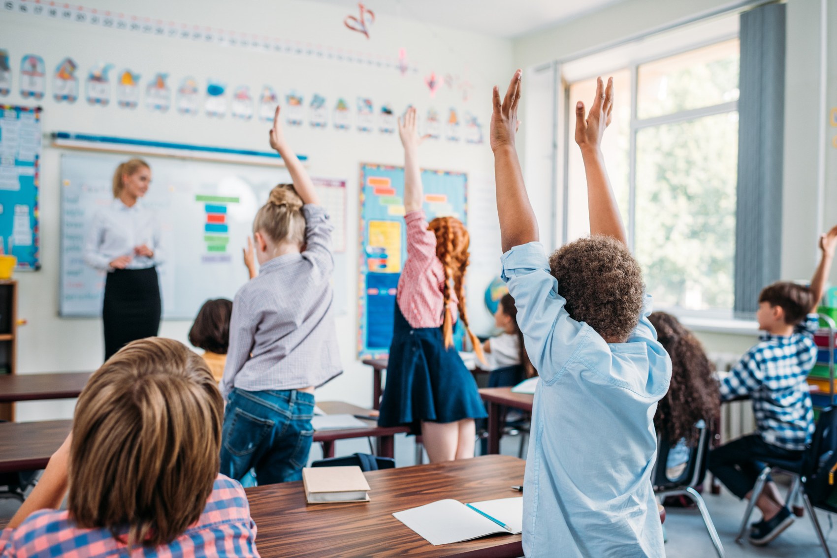 Pupils raising their hands in a classroom