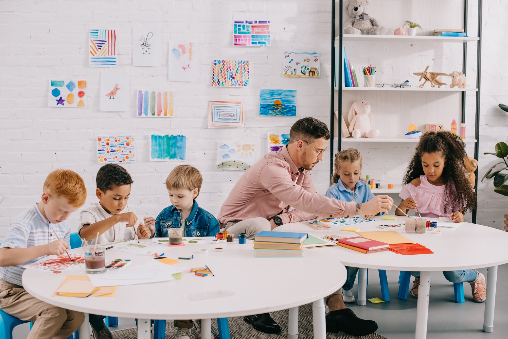 Teacher guiding children through a creative group activity