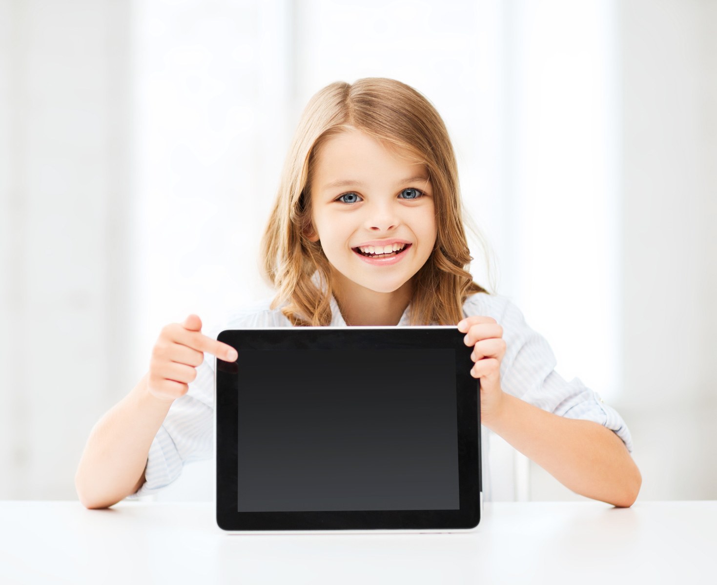 Smiling child holding a tablet